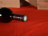 a bottle of wine sitting on a red table cloth