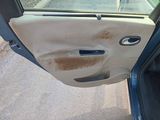 a dirty car door with the door handle missing
