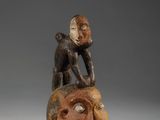 un gros plan sur la statue d'une personne assise sur un rocher