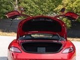 the back end of a red sports car with its trunk open