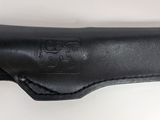 a close up of a black leather holster on a white wall