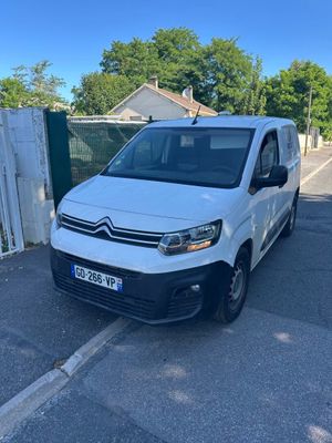 une camionnette blanche garée sur un parking près d'une clôture