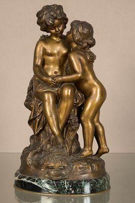 statue en bronze représentant deux enfants assis sur un rocher