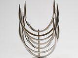 a metal sculpture that has been placed on a white surface