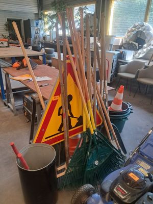 a pile of brooms and a mop on the floor