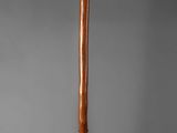 an old wooden baseball bat sitting on top of a metal stand