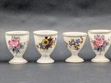 six white vases with different designs are lined up in a row