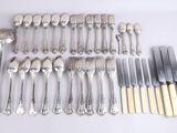 a lot of silverware on a table with knives and spoons