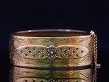 a close up of a gold bracelet with a chain around it