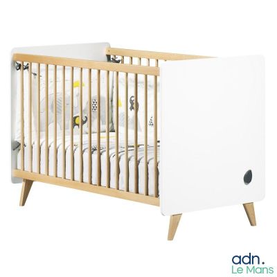 un lit de bébé blanc recouvert d'un drap blanc