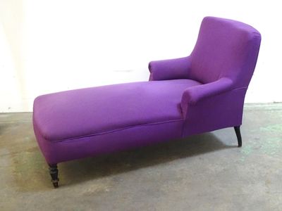 Méridienne à garniture violette, les pieds en bois noirci.