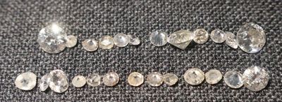 un gros plan sur un groupe de diamants blancs posés sur un tissu noir