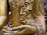 a gold statue of a person sitting on a chair