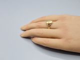 Quelqu'un porte une bague en or avec un cœur au milieu.