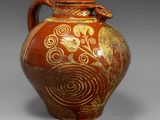 an image of a red and gold vase on a gray background