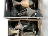 une boîte métallique remplie d'objets divers posée sur une surface blanche