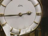 a clock that is in a glass case on the table