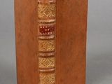an old book with a brown cover sitting on top of a table