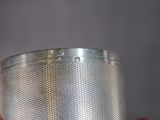 someone is holding a silver cup with a handle in their hand