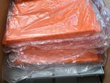 a cardboard box filled with orange sheets and plastic