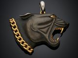une image représentant un pendentif noir et doré en forme de tête de chien