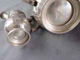 a silver tea pot and a silver teapot on a table