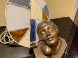 a small statue of a man sitting on a table next to a mirror