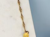 un gros plan d'un collier plaqué or orné d'une pièce de monnaie