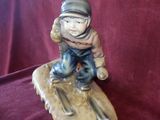 a figurine of a boy on a snowboard on a red cloth