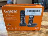 an orange box on a wooden table with a phone in it