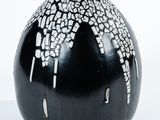un vase noir orné de motifs blancs et noirs