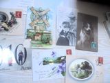 de nombreuses cartes et cartes postales posées sur une table, avec un moulin à vent