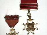 deux médailles et un ruban rouge sur un fond blanc