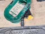 a green and yellow device sitting on the floor next to other tools