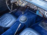 dashboard of an old car with blue carpet and leather seats