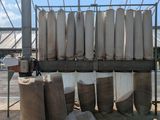 de nombreux rouleaux de tissu posés sur un support devant un bâtiment
