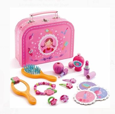 une valise rose contenant une brosse à cheveux rose, un peigne, des ciseaux et d'autres jouets