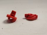 two pieces of red plastic on a white surface