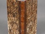 an old book with a brown cover sitting on top of a table