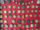 a picture of a display of gold and silver buttons on a red surface