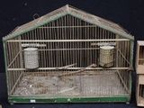 a bird cage with a bird inside of it on a table