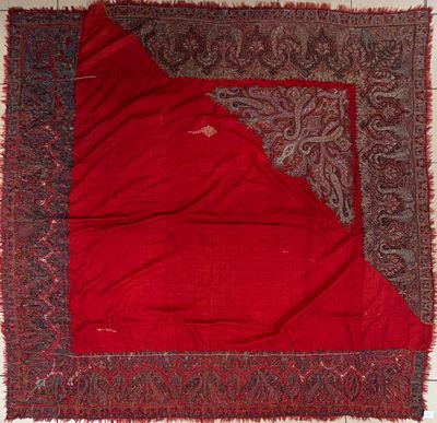 a close up of a red blanket with a paisley design on it