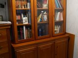 une armoire en bois avec des portes vitrées dans un salon