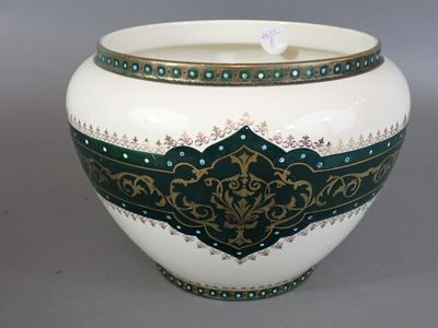 un vase blanc orné d'un motif vert et doré