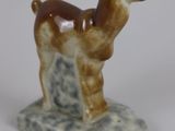 a small figurine of a llama on a marble base