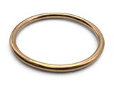 gros plan d'une bague en or sur fond blanc
