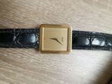a gold watch on a black leather strap