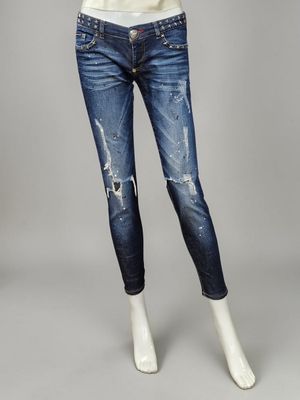 a woman wearing a white top and blue jeans stands in front of a mannequin mannequin