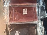 trois sacs en tissu marron, rouge et vert posés sur une table