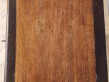 a wooden table with a brown top on a tile floor